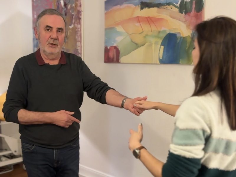 Francis guide une élève bras tendu pendant un cours particulier de danse